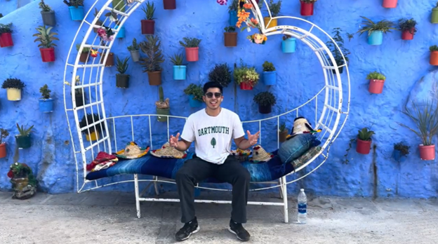 Student sitting on chair with blue wall behind in Morocco